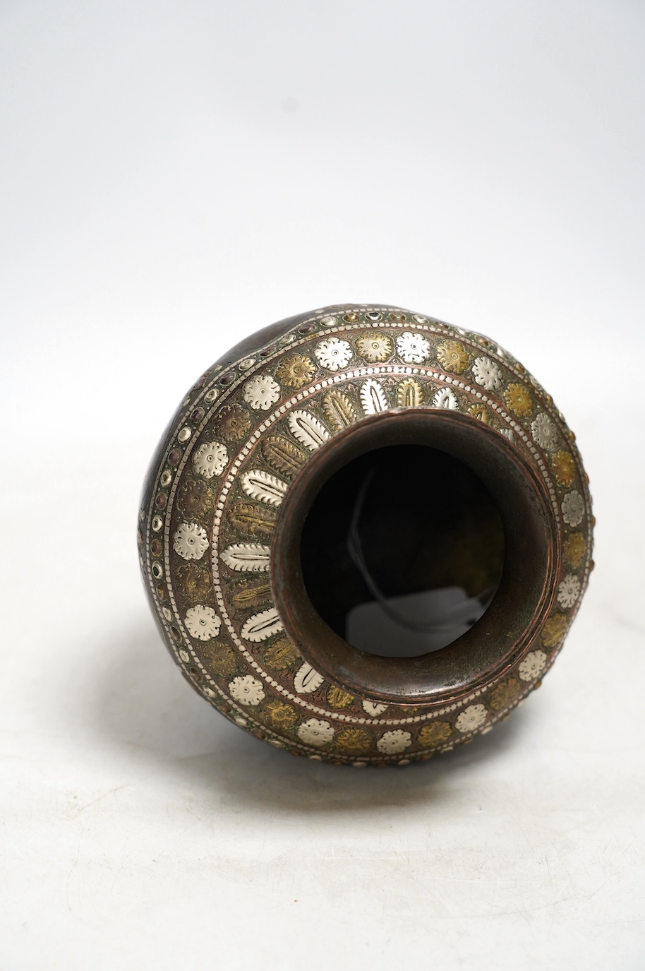 An Indian ganga jumna mixed metal water pot with engraved decoration, 14cm high. Condition - some dents